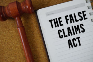 The False Claims Act text written on notebook paper with Judges Gavel