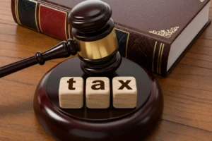 Gavel and book with tax blocks on wooden desk. Symbolizes tax law, legal proceedings, and financial justice. Represents taxation concepts and legal rulings in court.