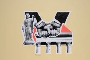 Handcuffed businessman hands with lady justice statue and courthouse pillars